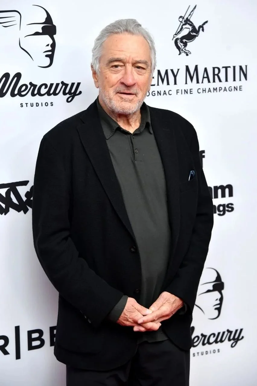 Robert de Niro u crnom saku i tamno sivoj polo majici