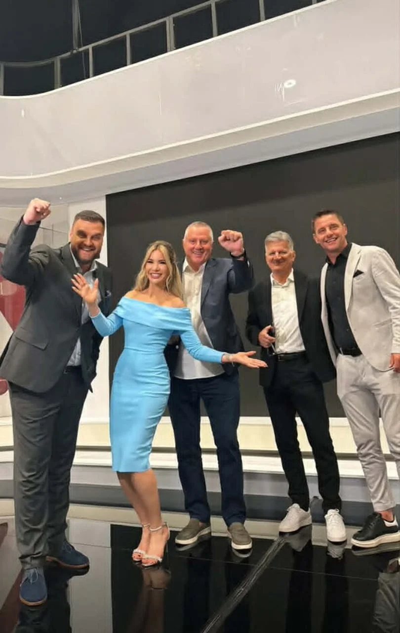 Grupa ljudi u poslovnoj odjeći pozira u studiju