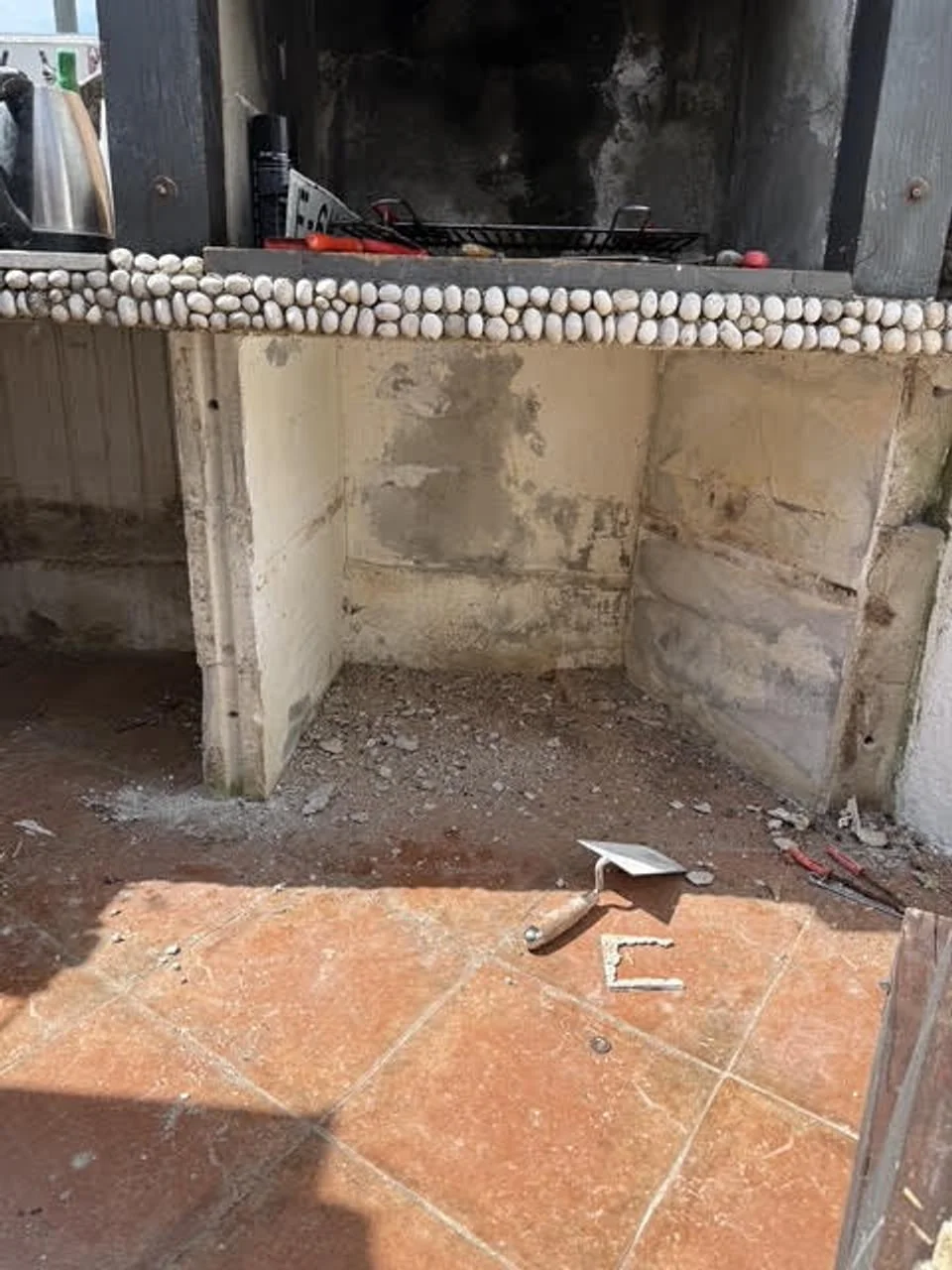 Stari vanjski grill s ostatcima žbuka i građevinskim alatom