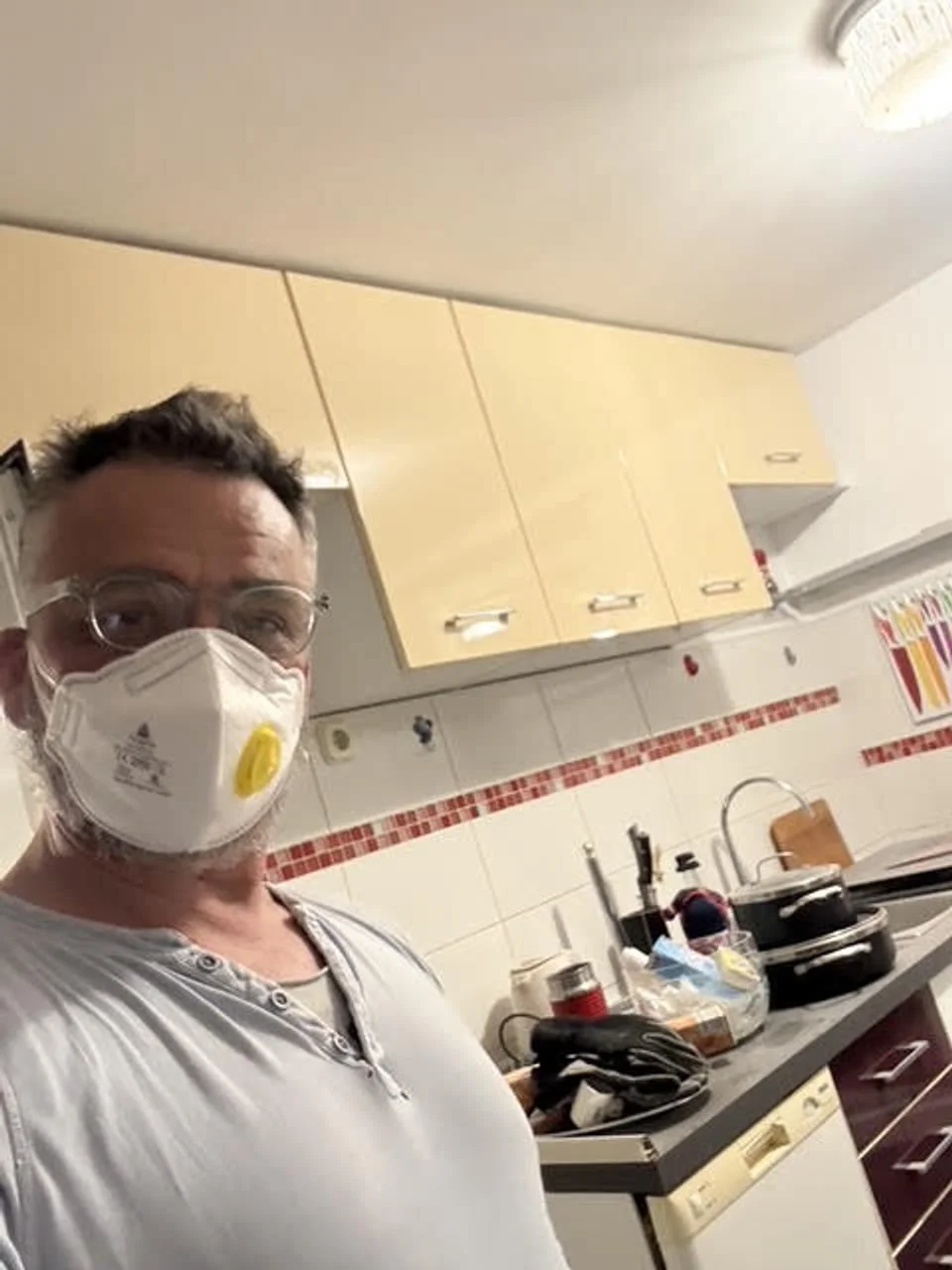 Muškarac s zaštitnom maskom i naočalama u kuhinji