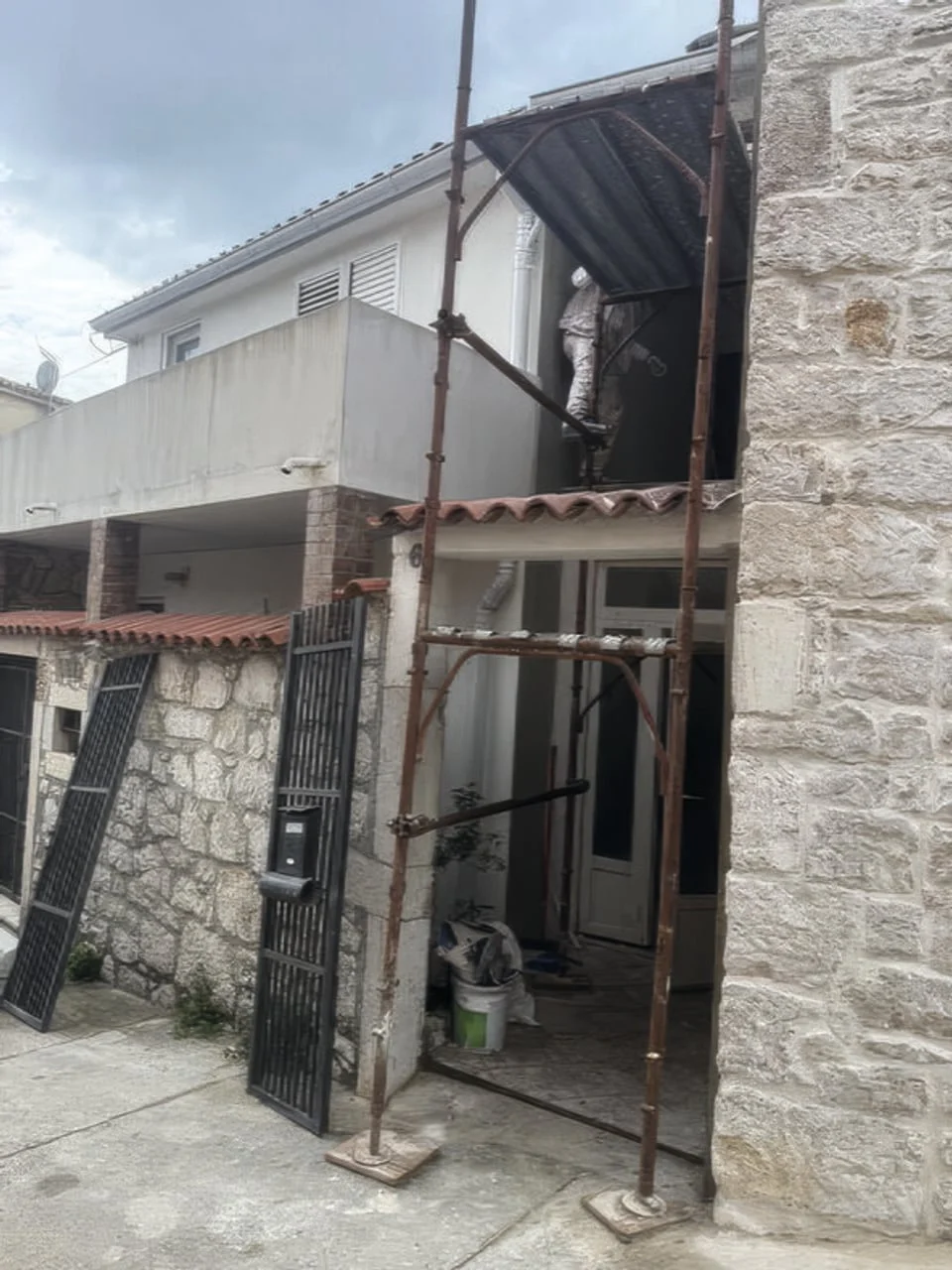 Metalna skela postavljena uz zid kamene kuće