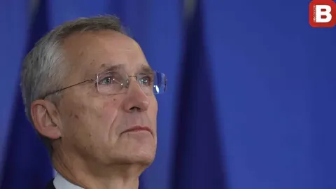 Portret Jens Stoltenberga s naočalama pred plavom pozadinom