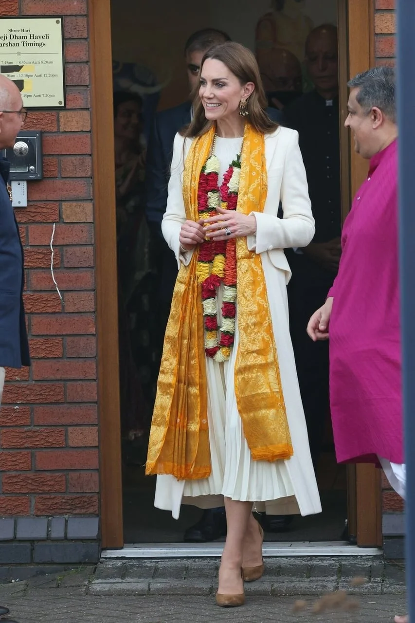 Kate Middleton u bijelom odelu s narančastim šalom i cvijećem