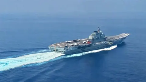 Veliki sivi kineski nosač aviona koji plovi kroz plavo more