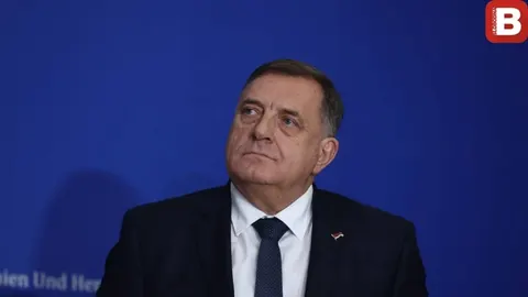 Portret Milorada Dodika u tamnom odelu i plavoj kravati na plavoj pozadini