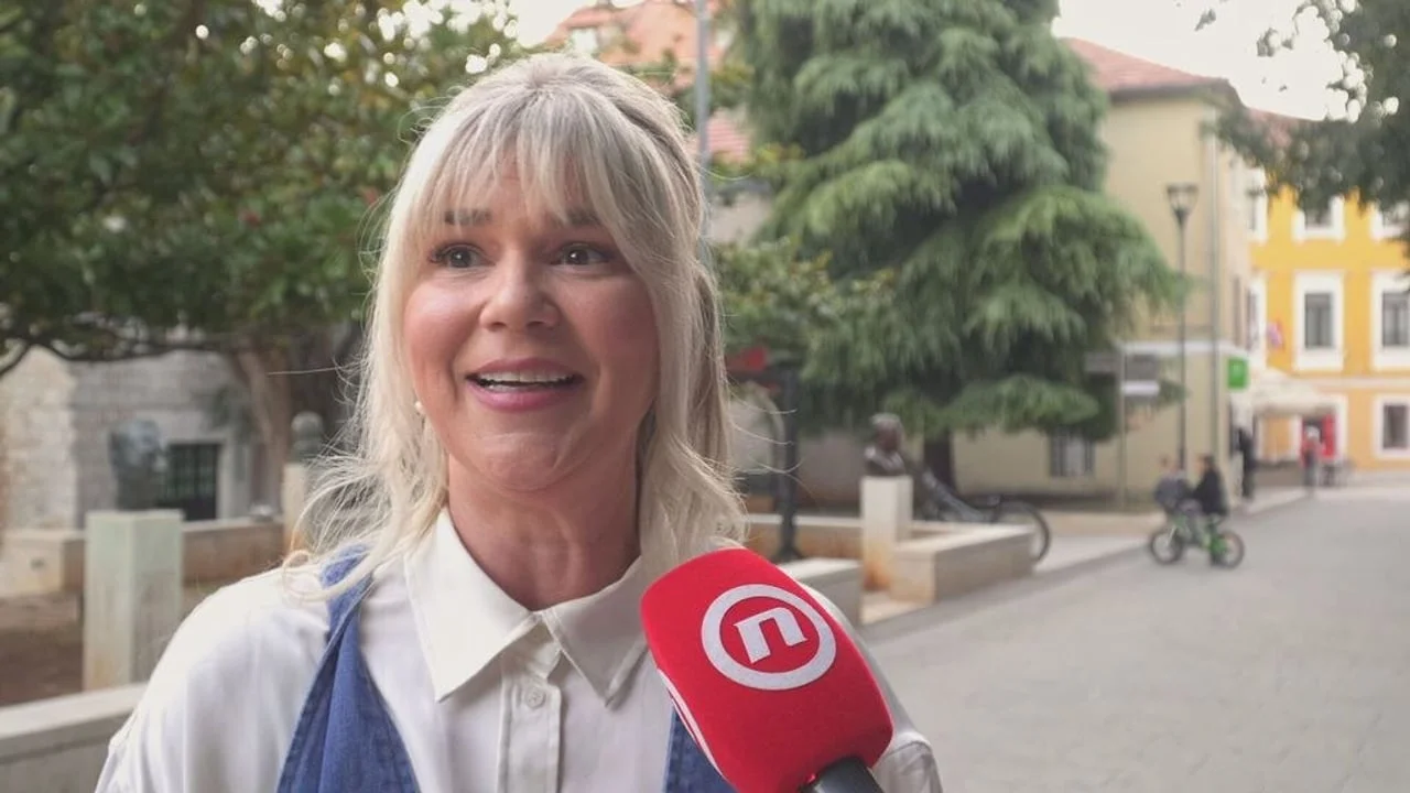 Žena plave kose koja govori u crveni mikrofon na ulici