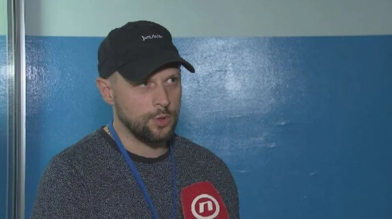 Portret pjevača Alana Hržice u crnom kapu i sivoj košulji