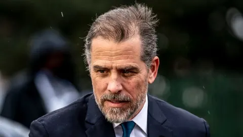 Portret Huntera Bidena u tamnom odjele s ozbiljnim izrazom lica