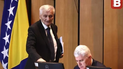 Dragan Čović u odelu stoji pored zastave Bosne i Hercegovine