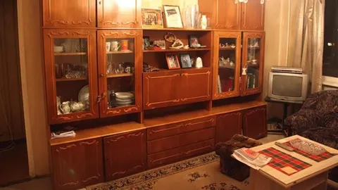 Stari drveni zidni regal s čašama i ukrasima u dnevnom boravku
