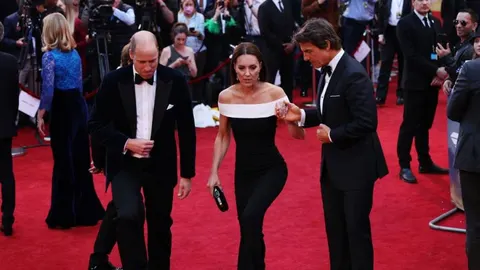 Tom Cruise i žena u elegantnim crnim odjevima na crvenom tepihu