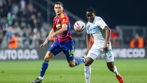 Dva nogometaša Hajduka i Rijeke u duelu za loptu na travnjaku tijekom utakmice.