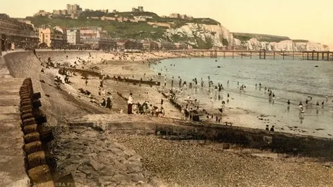 Stara razbojena fotografija obale s ljudima u kupaćim odjećama i dvorcem u pozadini
