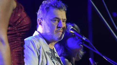 Krupni plan Alena Vitasovića koji pjeva u mikrofon pod plavim svjetlima