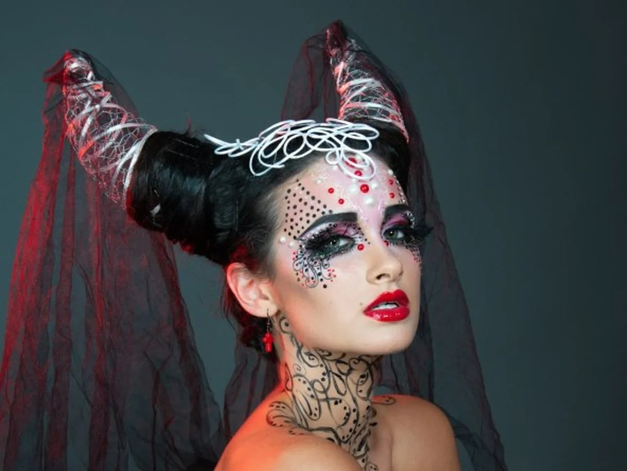Žena s dramatičnim crnim i crvenim šminkama i crnim velom