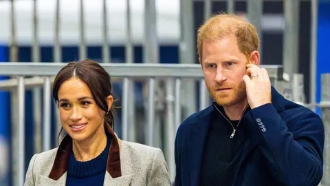Princ Harry i Meghan Markle stoje jedno uz drugo u zimnim kaputima