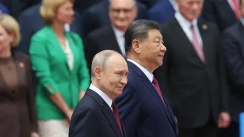 Vladimir Putin i Xi Jinping stoje jedan pored drugog u odelima