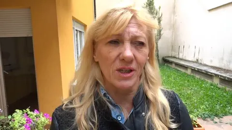 Portret plavuše Jadranke Jež u crnoj jakni ispred žute zgrade