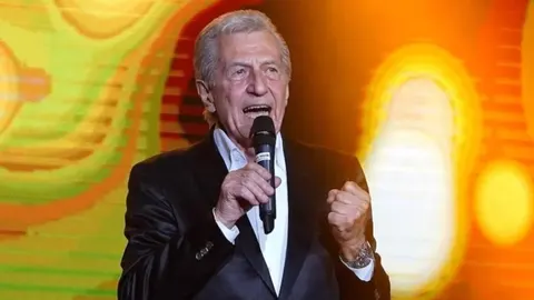 Miroslav Ilić pjeva u mikrofon na sceni pred šarenim osvjetljenjem