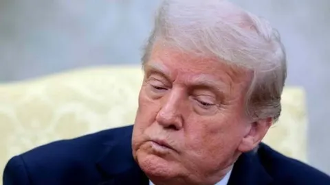 Portret Donalda Trumpa u tamnom odjeću s ozbiljnim izrazom lica.