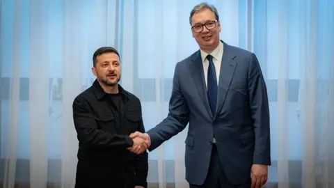Volodimir Zelenski i Aleksandar Vučić rukuju se u prostoriji.