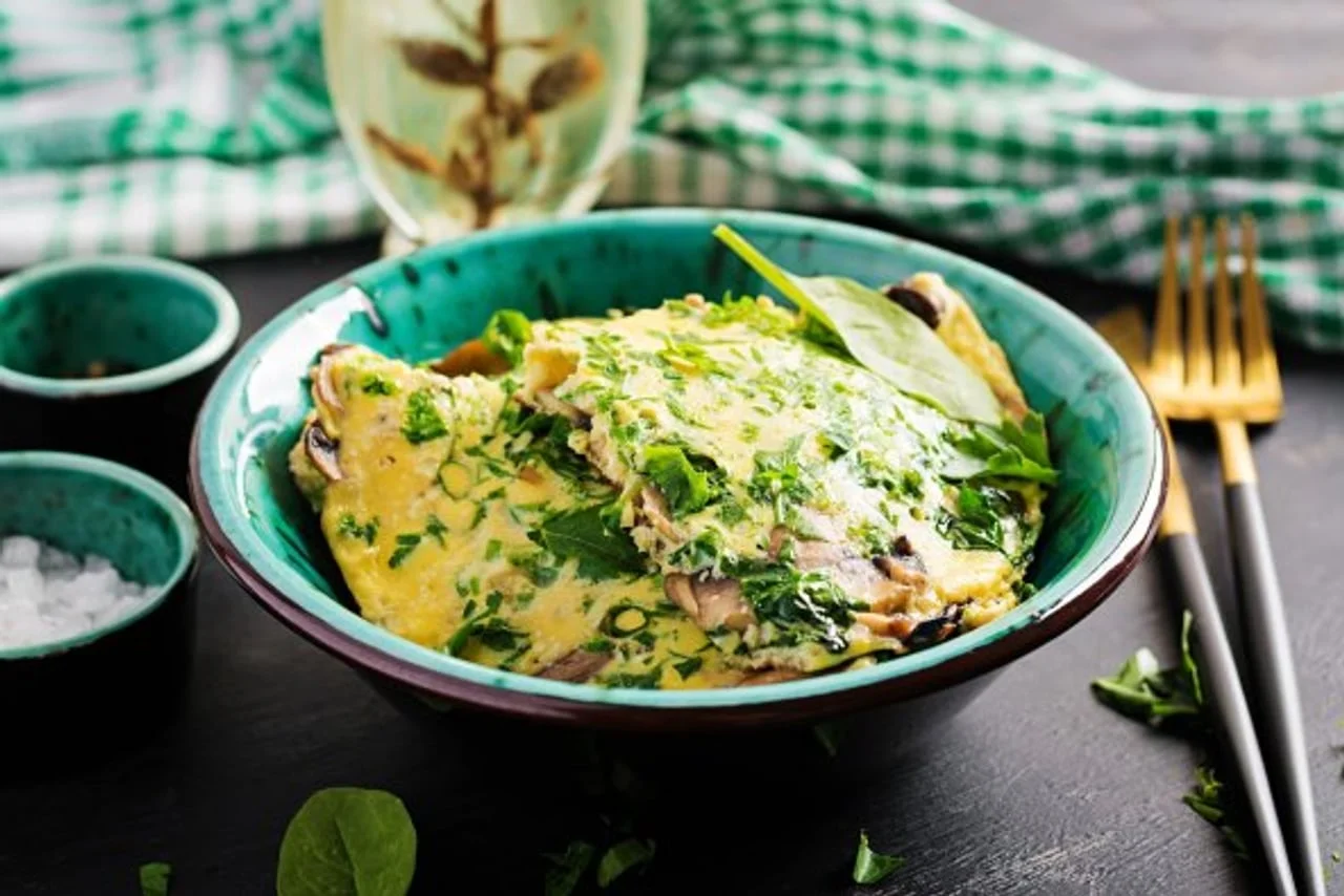 Omlet s povrćem i začinskim biljem u plavoj zdjeli