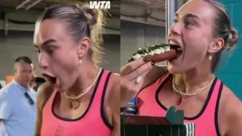 Arina Sabalenka u ružičastoj sportskoj majici jede luksuzni hot dog.