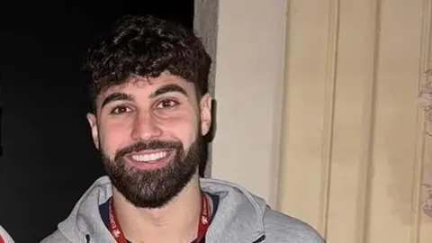 Portret nasmijanog nogometaša Joška Gvardiola u sivoj kapuljačastom majici