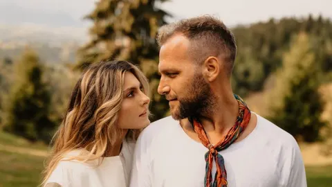 Blizak kadar muškarca i žene koji se nježno gledaju u prirodi