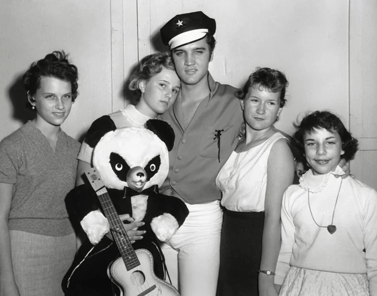 Elvis Presley u uniformi mornarice sa četiri mlade žene i plišanim medvedom