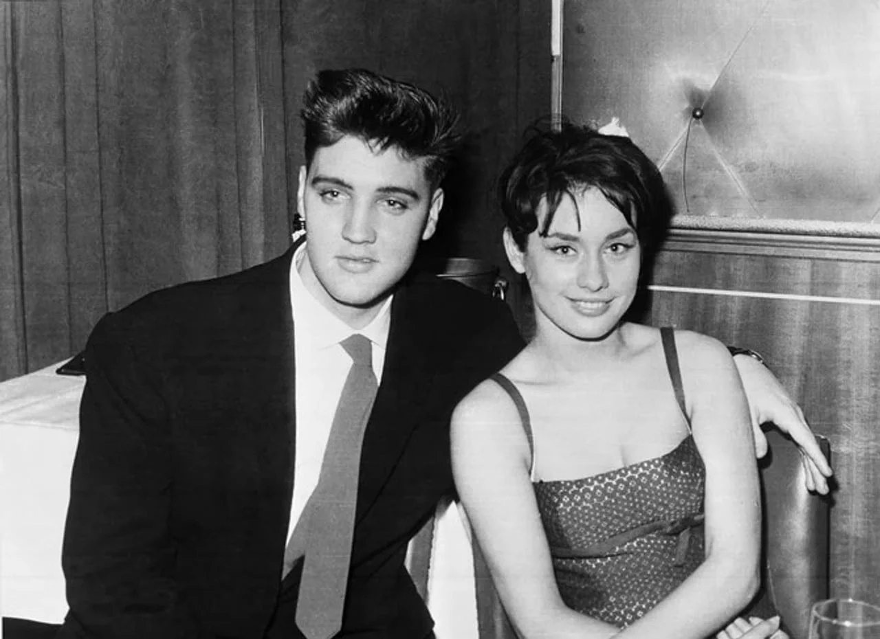Mladi Elvis Presley i žena u tamnoj haljini sede do jedne druge