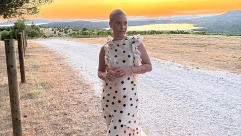 Katarina Baban u bijeloj haljini na točkice s čašom pića u prirodi