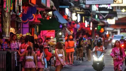 Noćna ulica u Pataji s neonskim svjetlima i skupinom žena