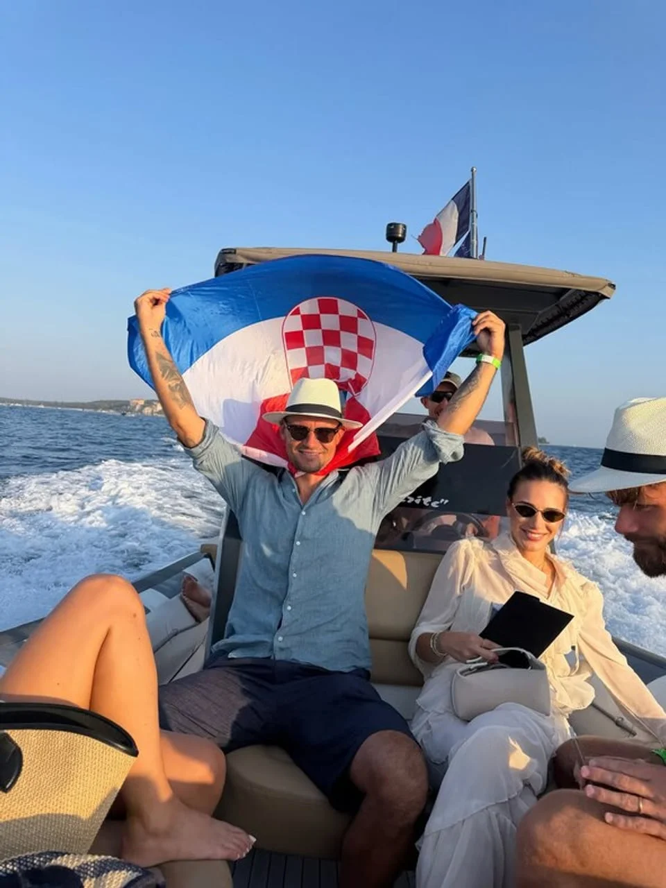 Muškarac s hrvatskom zastavom i žena na brodu