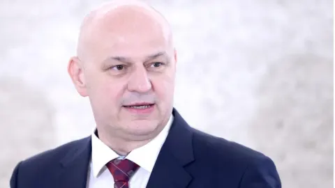 Mislav Kolakušić u tamnom odijelu s crvenom kravatom