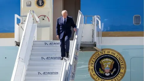 Donald Trump u tamnom odjełu spušta se stepenicama iz predsjedničkog aviona