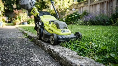 Žuta električna kosilica koja kosi travnjak uz rub betonskog rubnika