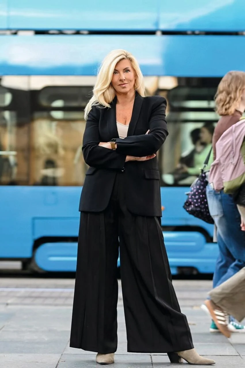 Žena u crnom odelu sC širokim hlačama na ulici