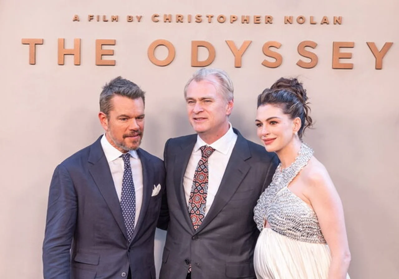 Matt Damon, muškarac u sivoj odeli i Luciana pred natpisom The Odyssey