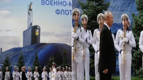 Vladimir Putin u crnom odelu pored mornara u bijelim uniformama i crteža podmornice