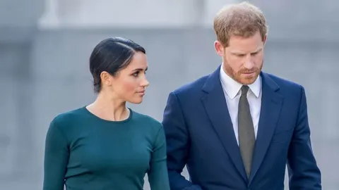 Princ Harry u plavom odelu i Meghan Markle u tamnozelenoj haljini