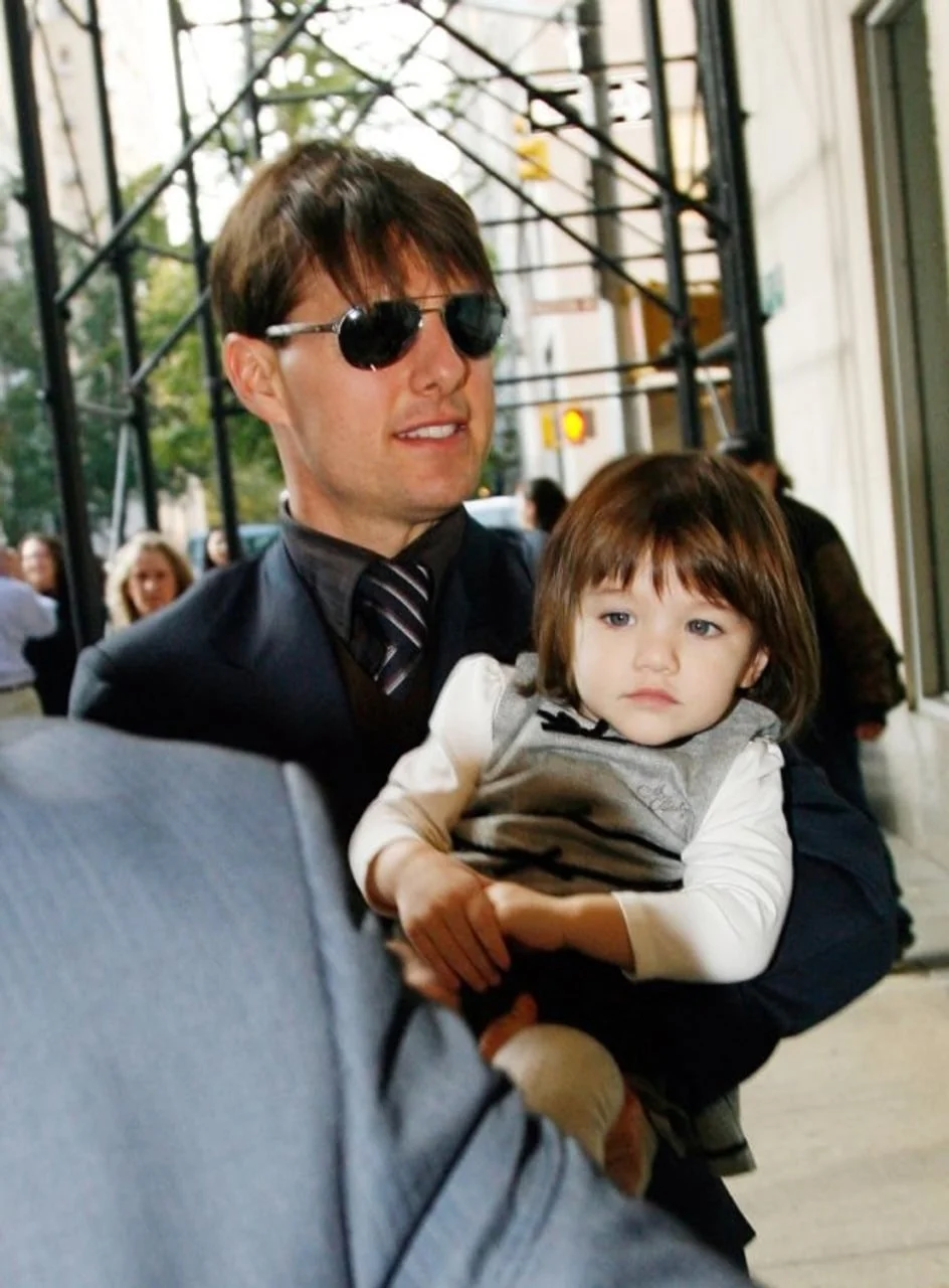 Tom Cruise u sunčanim naočalama drži malu Suri u naručju