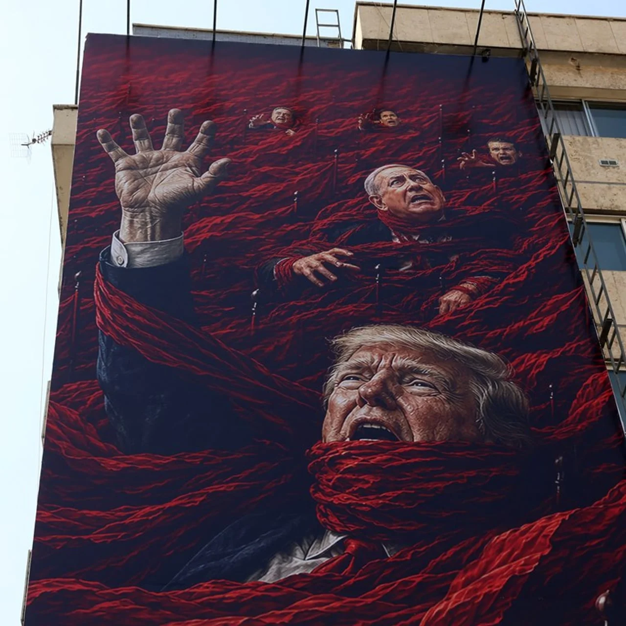 Veliki mural na zgradi koji prikazuje Trumpa i Netanyahua u crvenom tkanju