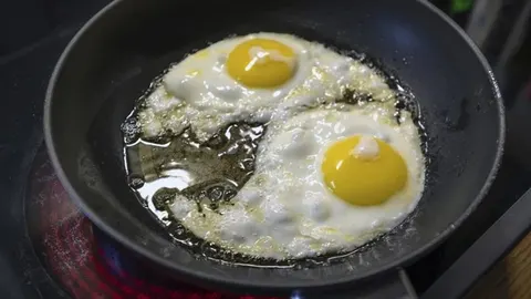 Dva jaja na oko koja se prže u tavi s masnoćom