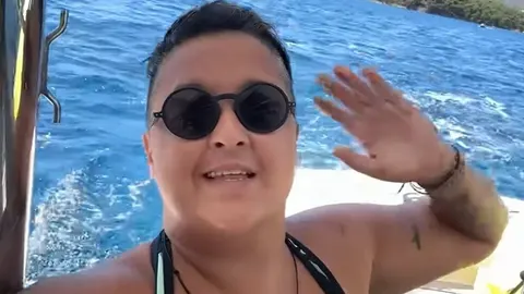 Marija Šerifović u sunčanim naočalama maše rukom na jedrilici