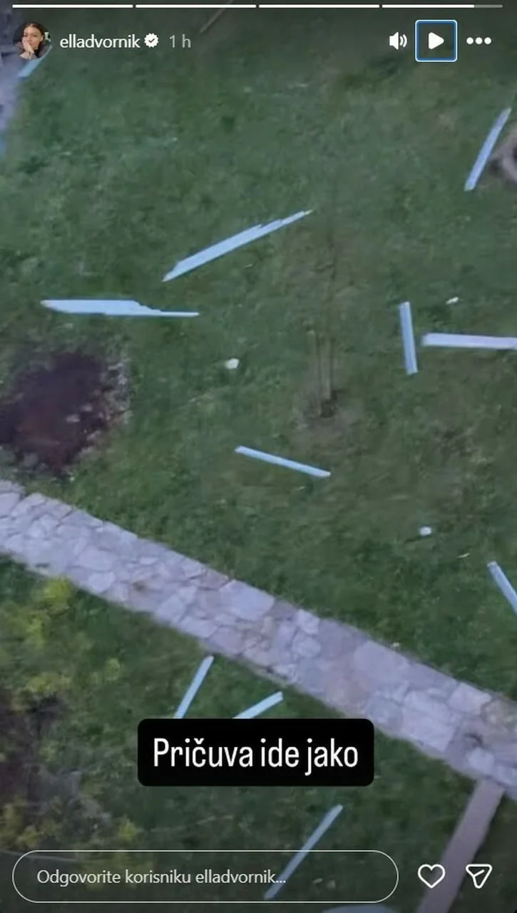 Razbacani dijelovi krovne konstrukcije na zelenoj površini ispred zgrade