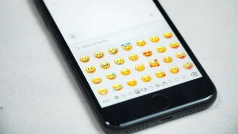 Zaslon pametnog telefona s prikazom različitih žutih emotikona za poruke.