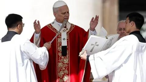 Papa Lav u crvenom ruhu s podignutim rukama služi misu uz pomoćnike.