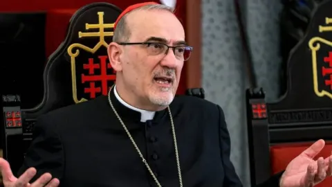 Kardinal Pierbattista Pizzaballa s naočalama i crvenom kapicom govori dok sjedi