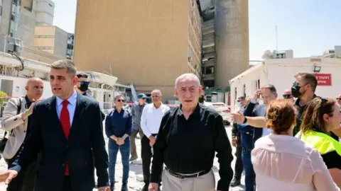 Benjamin Netanyahu u pratnji suradnika ispred oštećene zgrade